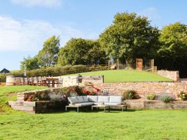 A garden with a sitting area and dining table at Higher Weekaborough Farm near Ipplepen