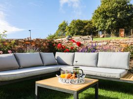An outdoor seating area with sofa and table at Higher Weekaborough Farm in Coombe Fishacre near Ipplepen