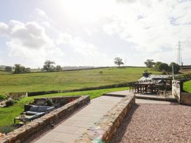 A garden with a couch and table overlooking the landscape at Higher Weekaborough Farm near Ipplepen