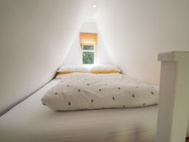 A bedroom with a bed and window at A-frame in Monewden near Otley, Suffolk