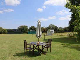 A table with chairs under an umbrella in an outdoor space at A-frame in Monewden near Otley, Suffolk