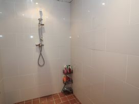 A shower with a shower head and shelf for products at A-frame in Monewden near Otley, Suffolk