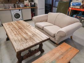 A sofa and coffee table in a room with kitchen appliances at A-frame in Monewden near Otley, Suffolk