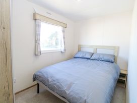 A bedroom with a double bed next to a window at 31A Foxburrow Hang in Fritton near Belton Norfolk