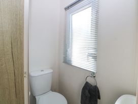 A bathroom with a toilet a window with blinds and a towel hanging on a ring at 31A Foxburrow Hang in Fritton near Belton Norfolk