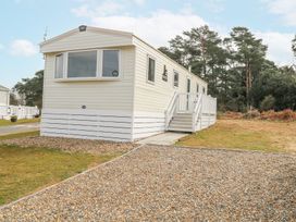 A beige mobile home with stairs and white railing located on a gravel and grass lot at 31A Foxburrow Hang in Fritton near Belton Norfolk