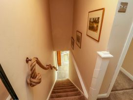 A staircase with carpeted steps and a rope handrail on the wall at Kirkland Howe Cottage in Arlecdon