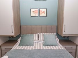 A bedroom with a bed and wall art at North Sands Beadnell
