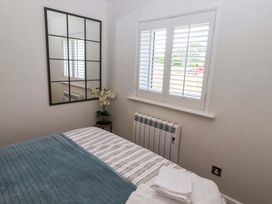 A bedroom with a bed and mirror at North Sands Beadnell