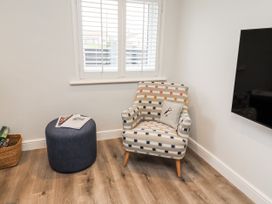 A living room with an armchair and ottoman at North Sands in Beadnell
