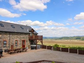 An outdoor area with a barn and deck overlooking fields at Llwyngwinau Isaf Barn Tynreithyn near Tregaron