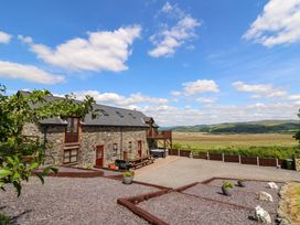 A stone house with outdoor seating and views at Llwyngwinau Isaf Barn Tynreithyn near Tregaron