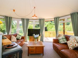 A conservatory with a sofa, coffee table, and tv at Dunromin in Montgomery