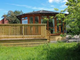 A garden structure with wooden deck and railing at Dunromin Montgomery