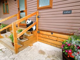 An outdoor entrance with a panda statue and potted plants at Dunromin in Montgomery