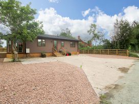A house with gravel driveway and trees at Dunromin Montgomery