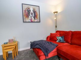 A living room with a red sofa and artwork at Dakota in Boot