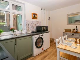 A kitchen with a washing machine and dining table at Dakota in Boot
