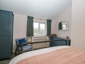 A bedroom with a bed, armchair, and dresser at Dakota in Boot