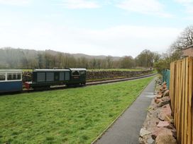 A train on tracks beside grass and path at Dakota in Boot