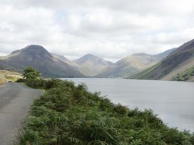 A road by a lake with mountains and greenery at Dakota in Boot
