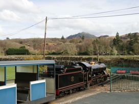 A steam locomotive with a train carriage and mountains in the background at Dakota in Boot