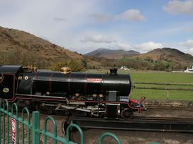 A steam locomotive on tracks with mountains in the background at Dakota in Boot