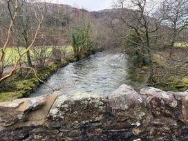 A river with trees and a stone wall near the water in Dakota near Boot