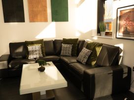 A corner seating area with a black leather sofa and a white coffee table at The Green Monkey in North Hykeham
