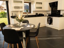 A kitchen with a round dining table and black chairs with flowers on the table at The Green Monkey in North Hykeham