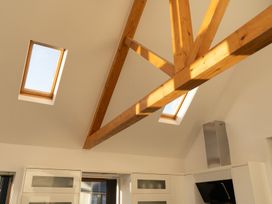 A kitchen ceiling with wooden beams skylights and white cabinets at The Green Monkey in North Hykeham