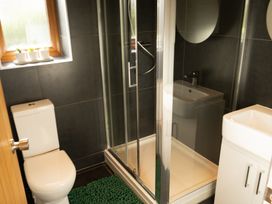 A bathroom with a toilet green mat shower cabin and sink with cabinet at The Green Monkey in North Hykeham