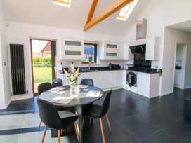 A kitchen with white cabinets a black round dining table with four chairs and skylights at The Green Monkey in North Hykeham
