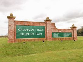 A brick sign with green panels displaying Caldecott Hall Country Park and amenities on a grass lawn at 31B Foxburrow Hang in Fritton near Belton Norfolk