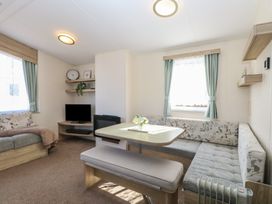 A living room with seating area dining table and television at 31B Foxburrow Hang in Fritton near Belton Norfolk