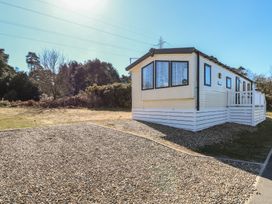 A mobile home on a gravel lot with trees and bushes in the background at 31B Foxburrow Hang in Fritton near Belton Norfolk