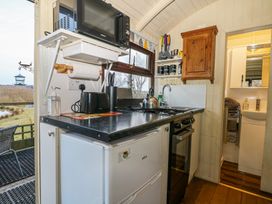 A small kitchen with a refrigerator microwave toaster and stove at Perch Hut Hadlow Down near Crowborough