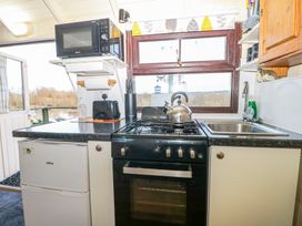 A kitchen with a stove, sink, microwave, toaster, and fridge at Perch Hut Hadlow Down near Crowborough