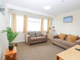 A living room with two sofas a small table with a plant and framed pictures on the walls at Chalet 21 in Newport Norfolk