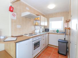A kitchen with stove oven microwave kettle toaster and sink at Chalet 21 in Newport Norfolk