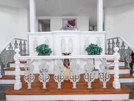 A staircase with ornate white and gray railings and potted plants at Trelowth Chapel in Polgooth
