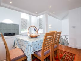 A dining area with wooden chairs and a table covered with a blue tablecloth at Trelowth Chapel in Polgooth