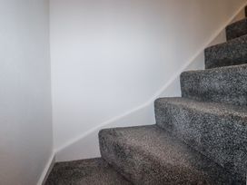 A carpeted staircase with grey carpet and white walls at Trelowth Chapel in Polgooth