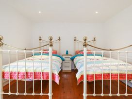 A bedroom with two single beds and a nightstand between them at Trelowth Chapel in Polgooth
