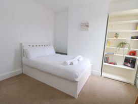 A bedroom with a bed and shelves at Weymouth Seaside House in Weymouth