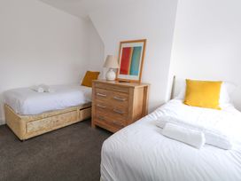 A bedroom with two beds and a drawer unit at Weymouth Seaside House in Weymouth