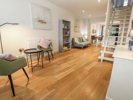 A living room with a sofa, armchairs, and a dining table at Harbourside in Weymouth