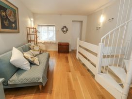 A living room with a sofa and staircase at Harbourside in Weymouth