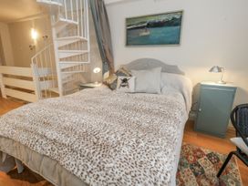 A bedroom with a bed and a spiral staircase at Harbourside in Weymouth