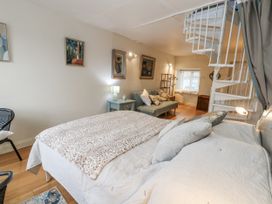 A bedroom with a bed, sofa, and staircase at Harbourside in Weymouth